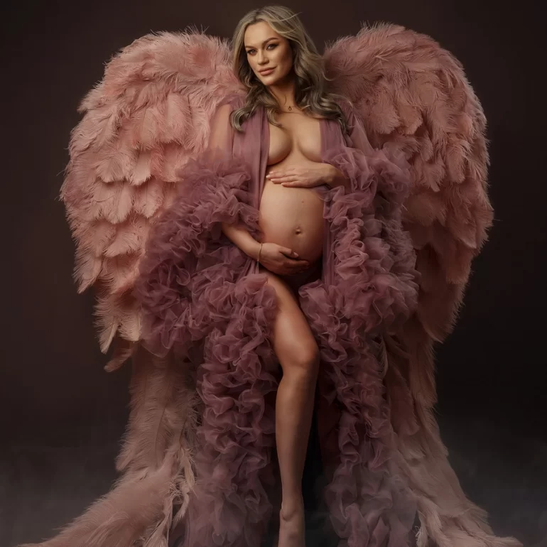 Blush ruffled gown with soft pink wings; tender hands on belly.