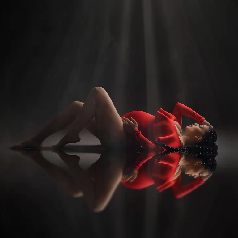 Vibrant red gown, pearl‑adorned braids; beams of light, cinematic feel.