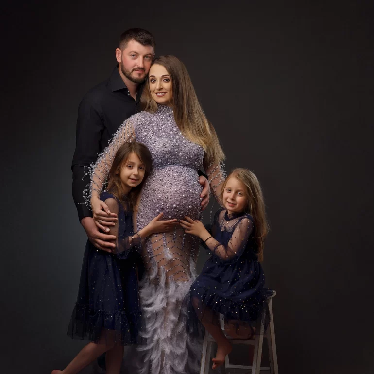 Family portrait: glamorous gown with pearls and feathers; joyful togetherness.