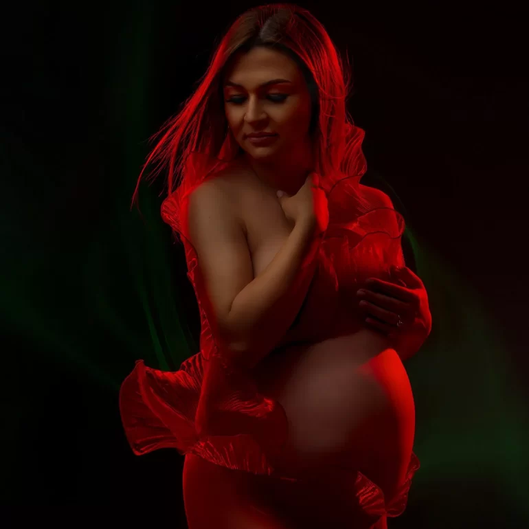 Red and green lighting; flowing red fabric adds motion and drama.