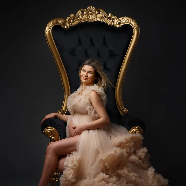 Throne portrait; layered beige gown; gold and black luxury.