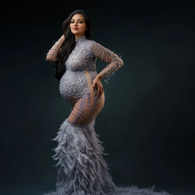 Sparkling, form‑fitting gown with feathered hem; poised confidence.