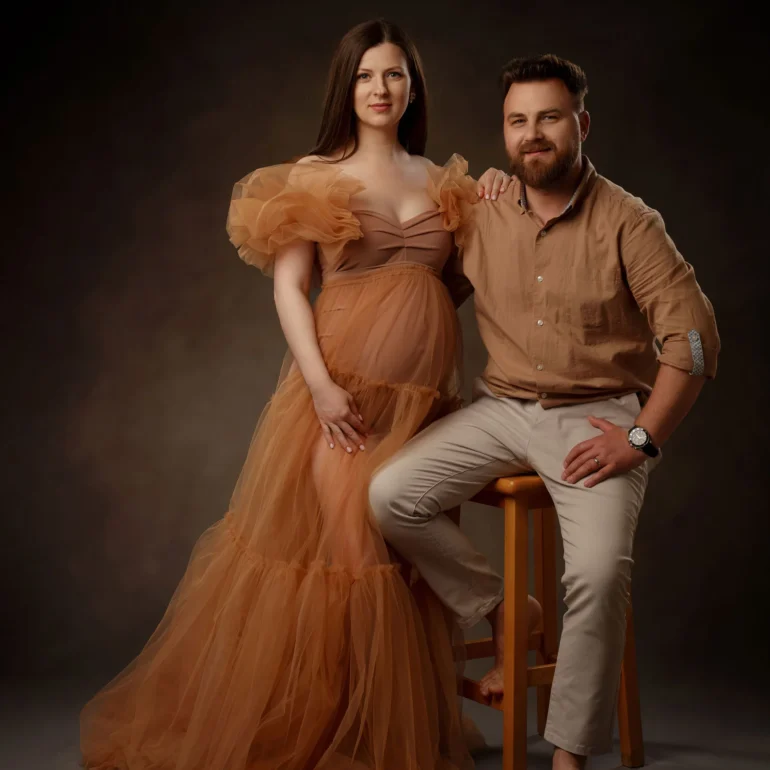Light‑brown ruffled gown; seated partner; earthy, serene tones.