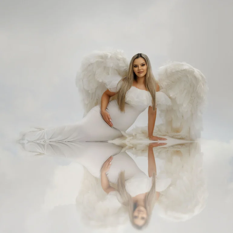 White wings reflected on glossy floor; dreamy, cloud‑like background.