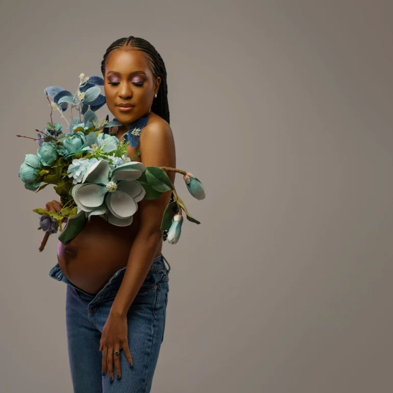 Unbuttoned jeans with pastel bouquet; natural, relaxed beauty.