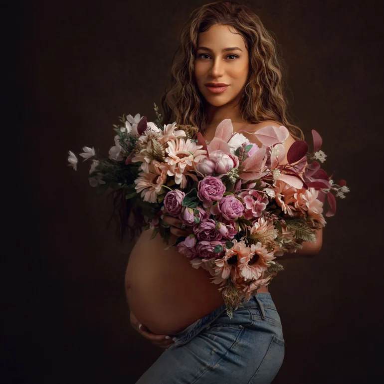 Blue jeans and bouquet of pink and peach blooms; warm studio feel.