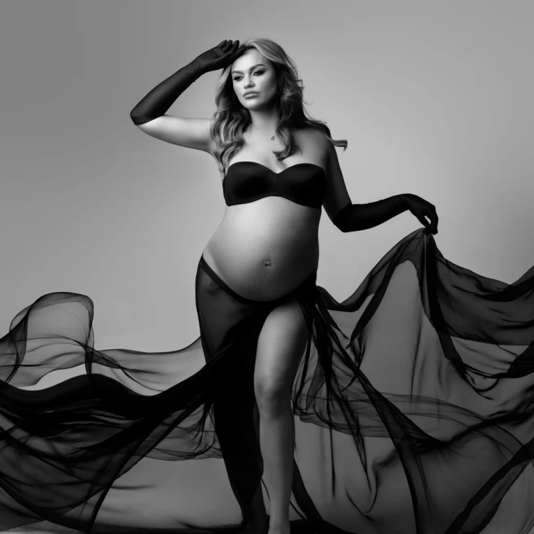 B&W studio portrait; black bandeau and cascading sheer fabric; strong lines.