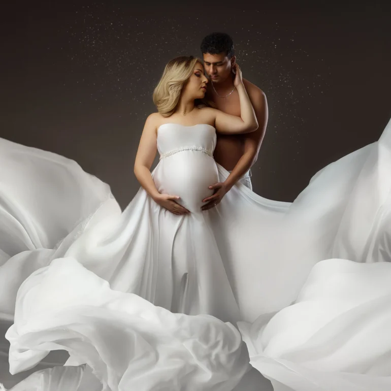 Couple amid flowing white fabric; cloud‑like, magical effect.